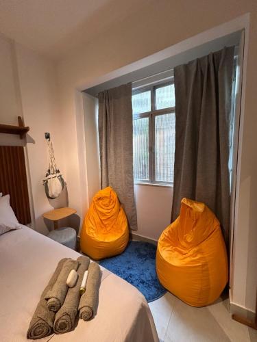 a bedroom with two orange ottomans and a bed at Studio Moderno in Botafogo in Rio de Janeiro