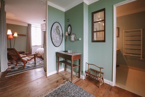 a room with green walls and a table and a chair at Les Chambres de Lasserre - Chambres et Table d'hôtes in Lasserre