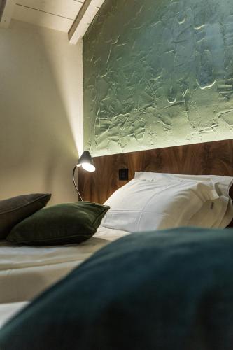 a bedroom with two beds with pillows and a lamp at Cà Toresele Relais Osteria Garden in Verona