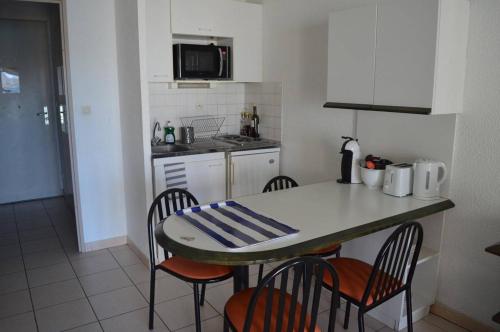 - une cuisine avec une table, des chaises et un comptoir dans l'établissement Appart Studio - cabine 4 couchages BANYULS SUR MER BN120-3204, à Banyuls-sur-Mer