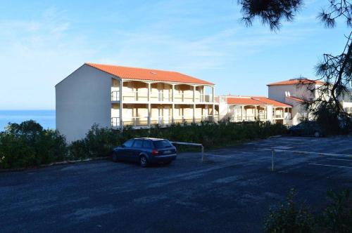 une voiture garée sur un parking devant un immeuble dans l'établissement Appart Studio - cabine 4 couchages BANYULS SUR MER BN120-3204, à Banyuls-sur-Mer
