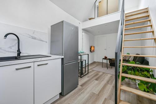 une cuisine avec une échelle menant à un loft dans l'établissement Le Felicie - Patio - Duplex - Paris & Disney, à Chennevières-sur-Marne