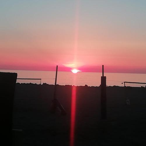 a sunset over the ocean with the sun setting at hopefco in Fiumicino