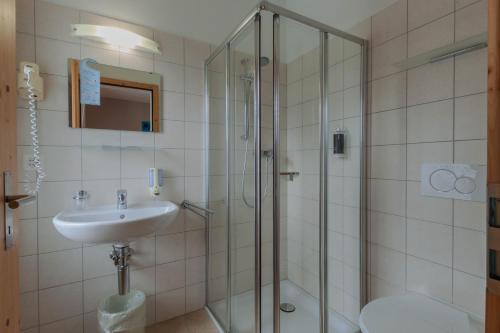 a bathroom with a sink and a shower at Ristorante Pensione Chalet Stazione in Poschiavo