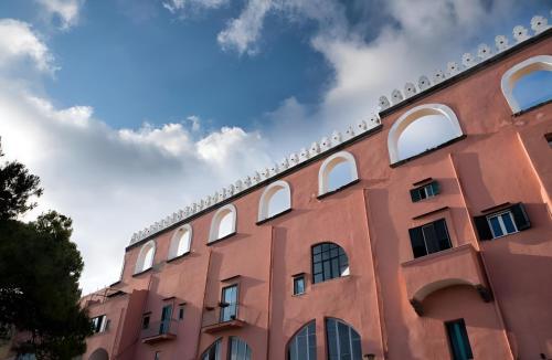 a red brick building with white windows on it at Mezza Torre B&B in Procida