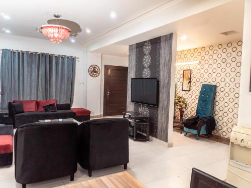 a living room with a couch and a tv at Family Comfort Suites in Rawalpindi