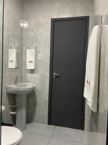 a bathroom with a black door and a sink at Pousada e Restaurante Manah in Propriá