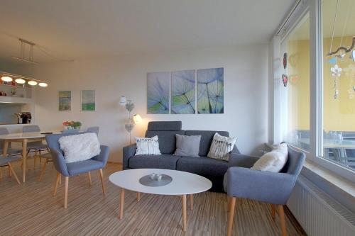 een woonkamer met een bank, stoelen en een tafel bij Apartment 238 in Hohegeiß