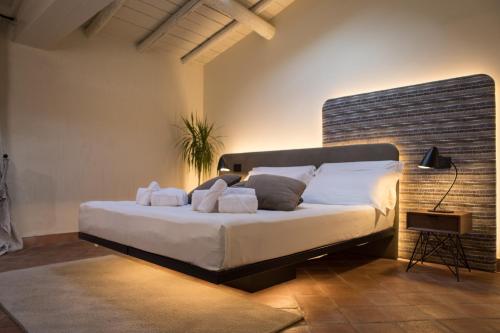 a bedroom with a large bed with white sheets and pillows at Cà Toresele Relais Osteria Garden in Verona
