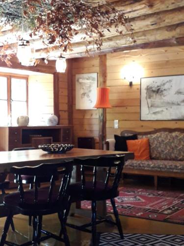 un salon avec une table, des chaises et un canapé dans l'établissement Notre Bergerie, à La Chaise-Dieu