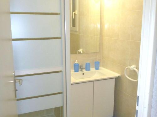 une salle de bain blanche avec un lavabo et un miroir dans l'établissement Studio Cabine Climatisé avec Piscine, Terrasse et Parking Privé – Proche Commodités - FR-1-387-137, à Marseillan