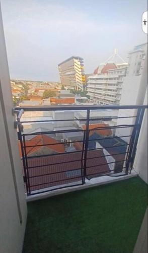 a balcony with a view of a city at The Square - King Suite - Apartemen Service - 2Person - NetFlix Wifi - Near Petra Campus in Surabaya