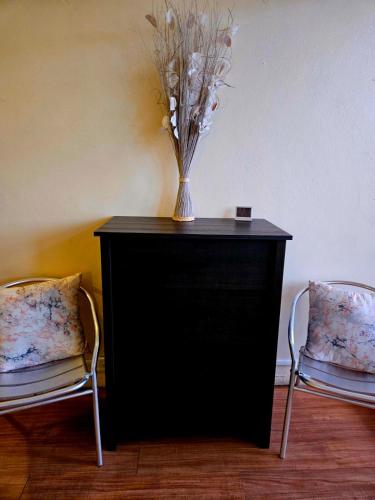 a vase on a black table with two chairs at West Side Studio Apartments in Anasco