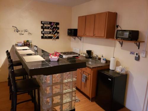 a kitchen with a counter and a stove and a refrigerator at West Side Studio Apartments in Anasco