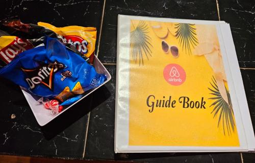 a box of chocolates and a book with a guide book at West Side Studio Apartments in Anasco