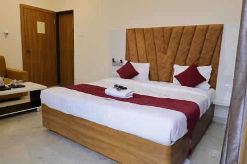 a bedroom with a large bed with a wooden headboard at Hotel The Prime Land in Hoshangābād
