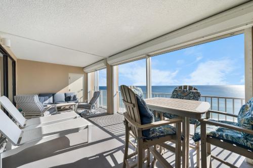 a balcony with chairs and a table with a view of the ocean at Bluewater Vacation Rentals in Orange Beach