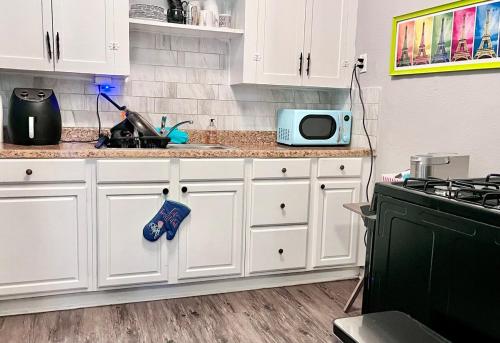un bancone della cucina con armadi bianchi e forno a microonde di Coastal between Galveston Kemah a Texas City