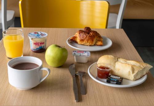 a table with a plate of food and an apple and a cup of coffee at B&B HOTEL Beauvais in Beauvais