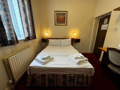 a bedroom with a bed with towels on it at Bridge Park Hotel in London