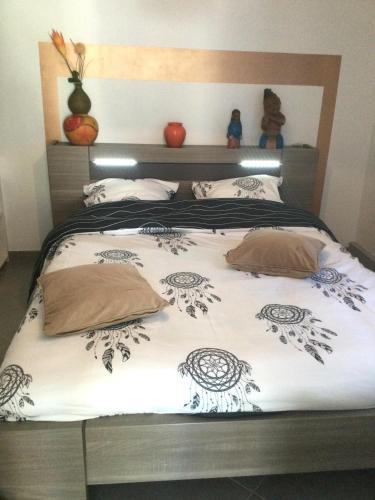 une chambre avec un lit avec une couette noire et blanche dans l'établissement L'abri côtier du Pic Saint Loup dans l Hérault, à Prades-le-Lez