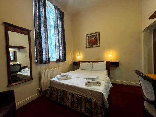 a bedroom with a bed with towels on it at Bridge Park Hotel in London