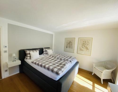a bedroom with a large bed and a chair at Landhaus Constantin Luxus-Appartments in Berchtesgaden