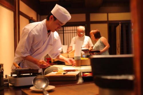 a group of people in a kitchen preparing food at Onyado Tsutaya in Kiso