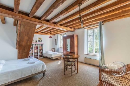 a bedroom with a bed and a table and chairs at Maison familiale dans le Perche in Chêne