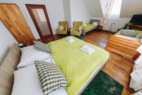 a bedroom with a large bed with a yellow blanket at Wellness Penzion Zora Family in Tatranská Lomnica
