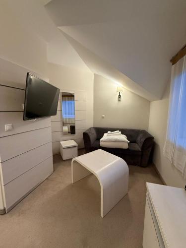 a living room with a couch and a flat screen tv at Hotel Karpik Zator Graboszyce in Graboszyce