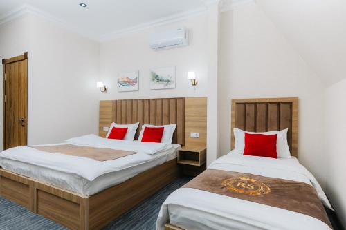 two beds in a room with red pillows at Royal Sebzor Hotel in Tashkent