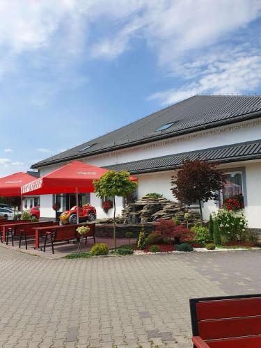 a restaurant with benches in front of a building at Hotel Karpik Zator Graboszyce in Graboszyce