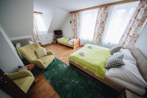 a small bedroom with a bed and two chairs at Wellness Penzion Zora Family in Tatranská Lomnica