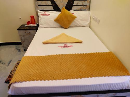a bed with a blanket on top of it at Hotel SONIA MAHI INN KANYAKUMARI in Kanyakumari
