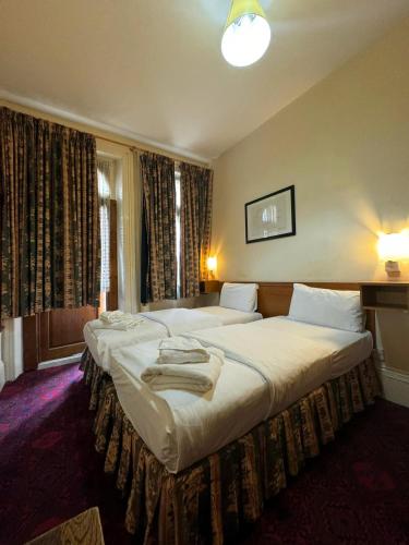 a hotel room with two beds in a bedroom at Bridge Park Hotel in London