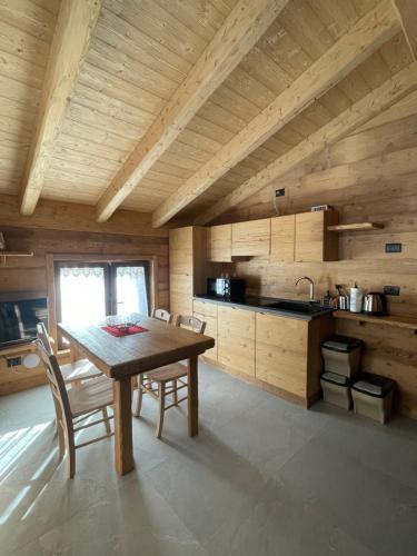 a kitchen with a table and chairs in a room at Sabbionaccio Apartments & Spa in Chiesa in Valmalenco