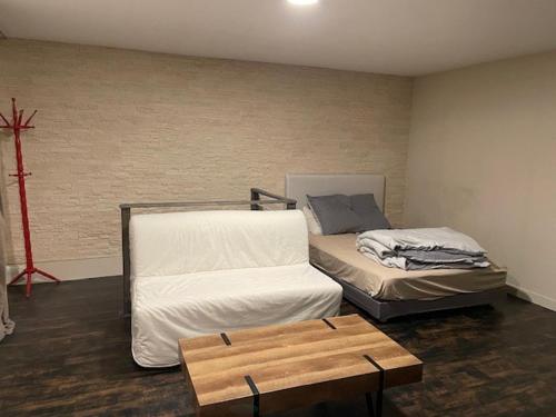 Cette chambre comprend 2 lits et une table en bois. dans l'établissement Grand studio atypique, à Courbevoie