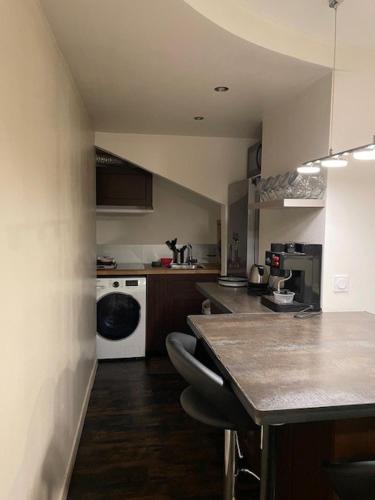 - une petite cuisine avec une table et un comptoir dans l'établissement Grand studio atypique, à Courbevoie