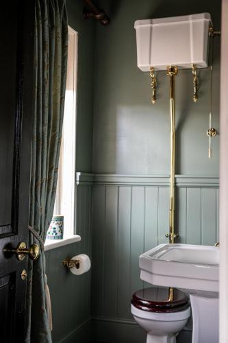 a bathroom with a toilet and a window at The Townhouse Sherborne in Sherborne