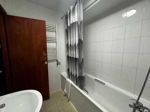 a bathroom with a bath tub and a sink at Bridge Park Hotel in London