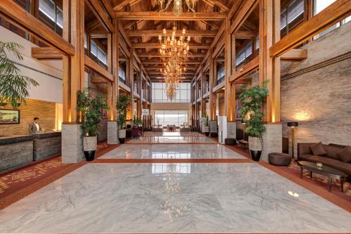 a large lobby with a large ceiling with plants at Pearl Continental Hotel, Muzaffarabad in Muzaffarabad