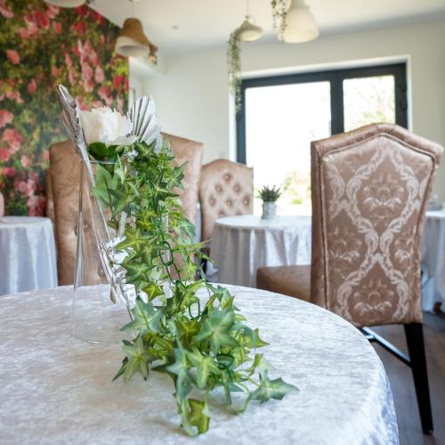 a table with a vase with flowers on it at Le Jardin d'Eden by Leslodgespa in Blotzheim