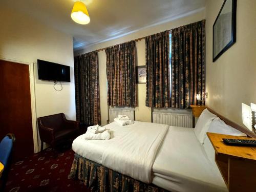 a hotel room with a bed and a desk at Bridge Park Hotel in London