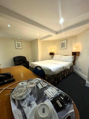 a hotel room with a bed and a table with dishes on it at Bridge Park Hotel in London