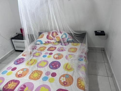 a bed with a comforter on it in a room at Gîte le Petit Manguier in Les Abymes