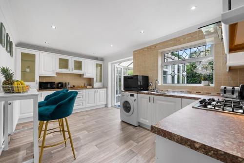 a kitchen with white cabinets and a washer and dryer at Modern 3 Bed House, Sleeps 6, Near NEC - Airport, Free Parking, Contractors - Families Stay in Sheldon