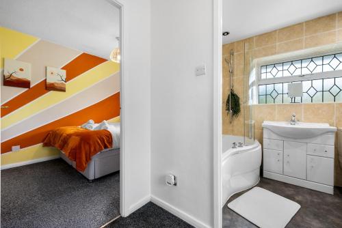 a bathroom with a rainbow accent wall and a bed at Modern 3 Bed House, Sleeps 6, Near NEC - Airport, Free Parking, Contractors - Families Stay in Sheldon
