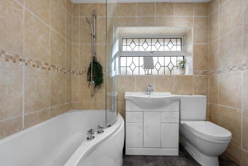 a bathroom with a tub and a sink and a toilet at Modern 3 Bed House, Sleeps 6, Near NEC - Airport, Free Parking, Contractors - Families Stay in Sheldon