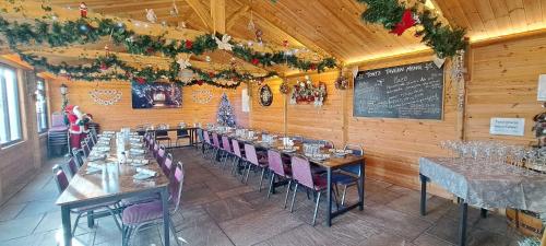 a dining room with tables and chairs and a chalkboard at Glamping Dome Elysian Fields in Helston